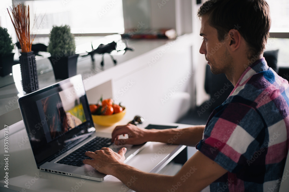 Young Designer Working on Laptop at his Home Office Young Designer Working on Laptop at his Home Office