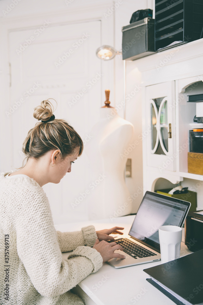 Young woman working on a laptop in home studio Young woman working on a laptop in home studio