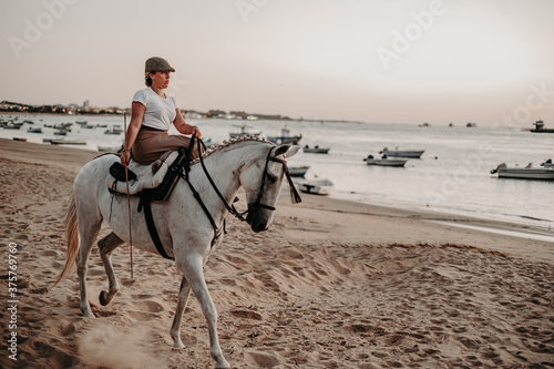 Chica con caballo yegua tordo torda playa natural camino trote doma playa salina camino naturaleza sanlucar rocio virgen campo ecuestre