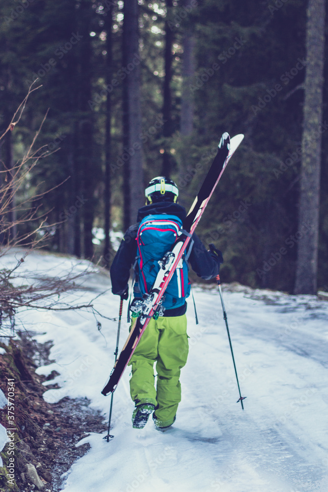 Freerider walking through the forest with his whole skiing equip Freerider walking through the forest with his whole skiing equip