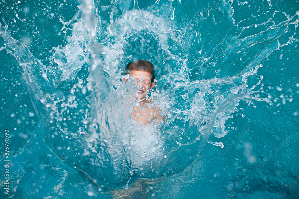 water in movement / splashes as child jumps into a swimming pool water in movement / splashes as child jumps into a swimming pool