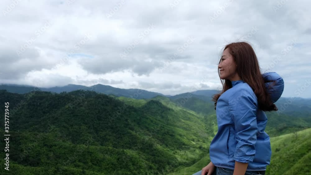 A female traveler looking at a beautiful green mountains view A female traveler looking at a beautiful green mountains view