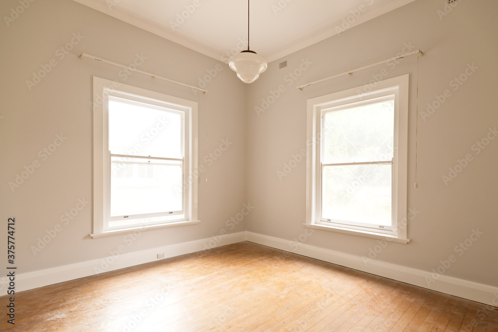 empty room with two bright windows and art deco light fitting empty room with two bright windows and art deco light fitting