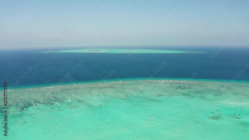 Tropical coral atoll with turquoise water against the sky with clouds top view. Summer and travel vacation concept. Balabac, Palawan, Philippines Tropical coral atoll with turquoise water against the sky with clouds top view. Summer and travel vacation concept. Balabac, Palawan, Philippines
