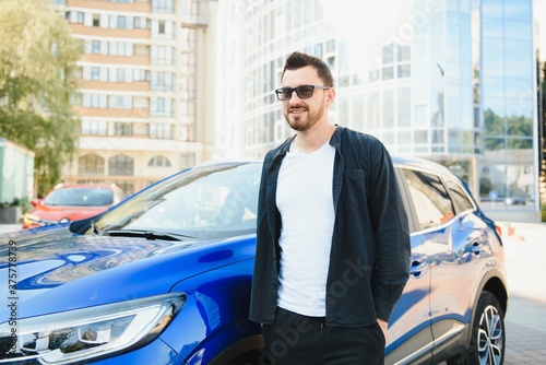 Handsome young man in standing near car outdoors © Serhii