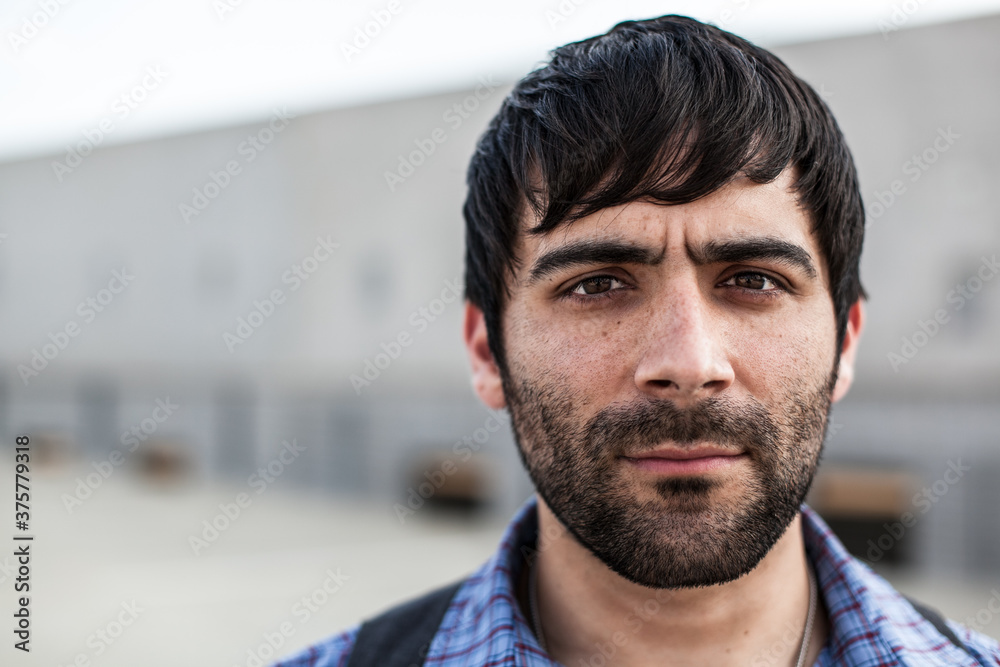 A man with dark hear and beard looking concerned directly into camera A man with dark hear and beard looking concerned directly into camera