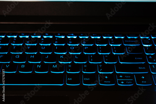 Close up shot of blue backlit laptop keyboard