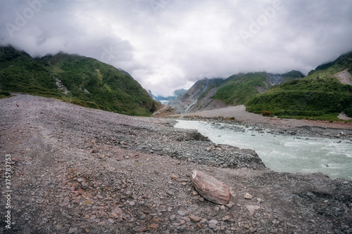 Low angle perspective view in Waiho River Valley towards Franz Josef Glacier located in Westland Tai Poutini National Park on the West Coast of New Zealand's South Island.  photo