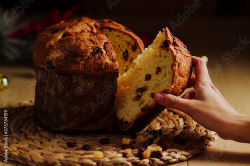 Woman hand taking a piece of Panettone