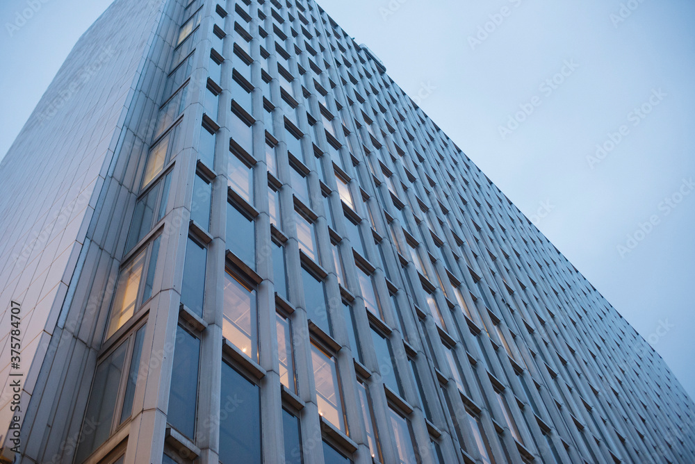 Low shot looking up of modern urban style office block shot at dusk. Low shot looking up of modern urban style office block shot at dusk.