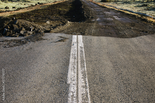 Close shot of road that ends abruptly into a hole. photo