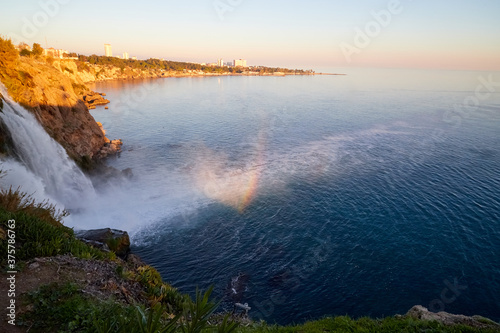 Waterfall with water falling in sea in the evening time. Waterfall Duden at Antalya in Turkey. Concept of nature travel