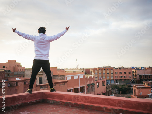 Arabic man on roof fucking the whole city with raised middle fingers photo