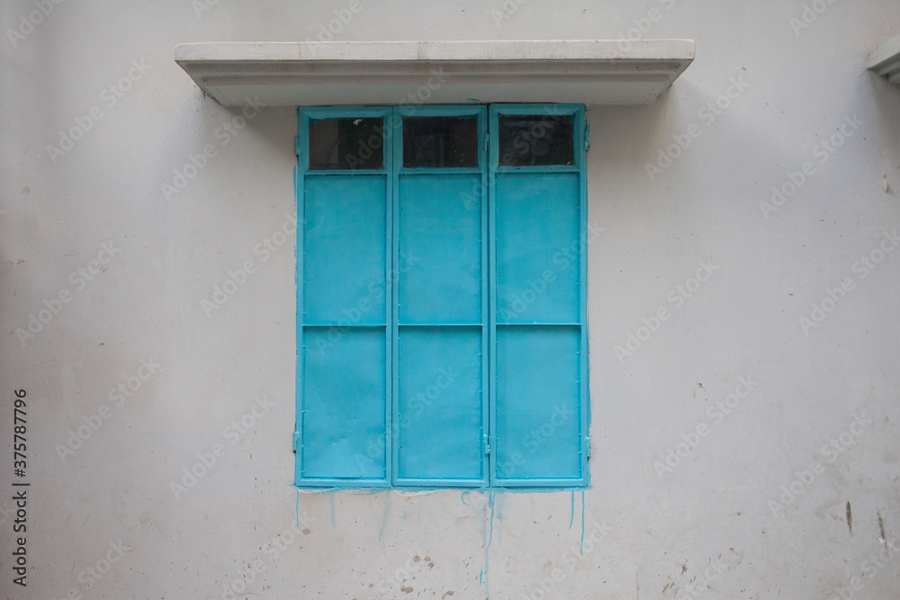 White wall with blue metal window. White wall with blue metal window.
