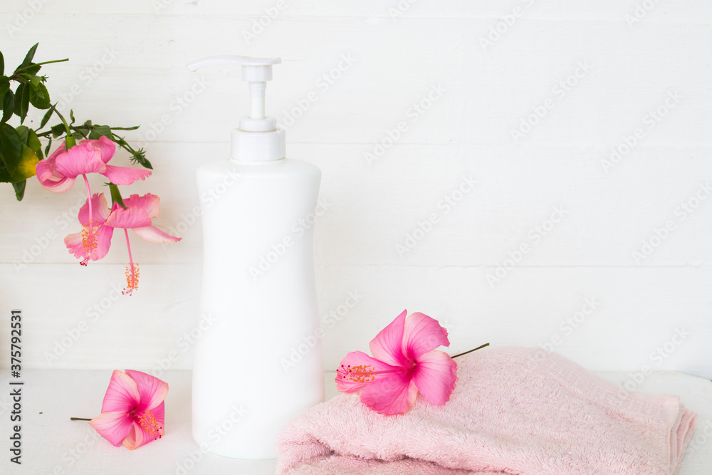 herbal liquid soap health care for body skin with terry cloth ,pink flower hibiscus arrangement flat lay style on background white herbal liquid soap health care for body skin with terry cloth ,pink flower hibiscus arrangement flat lay style on background white