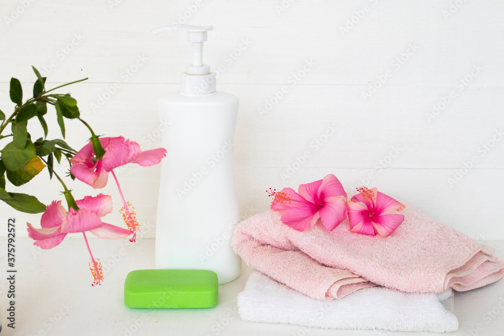herbal liquid soap health care for body skin with terry cloth ,pink flower hibiscus arrangement flat lay style on background white 