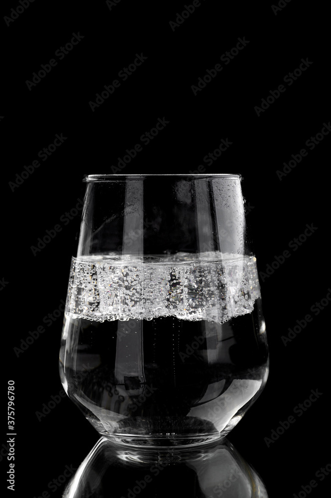 soda water with ice in a glass on a black background soda water with ice in a glass on a black background