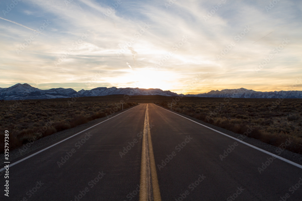 Sunset with Snow Mountain Range and Deserted Road Sunset with Snow Mountain Range and Deserted Road