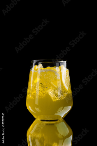  refreshing lemonade with lemon slices and ice cubes on black background