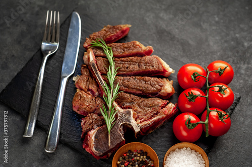 grill t-bone steak with ingredients on stone background