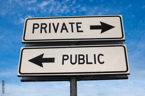 Private vs public. White two street signs with arrow on metal pole with word. Directional road. Crossroads Road Sign, Two Arrow. Blue sky background. Two way road sign with text.