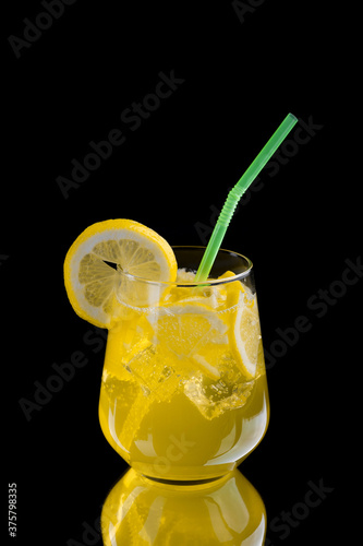  refreshing lemonade with lemon slices and ice cubes on black background