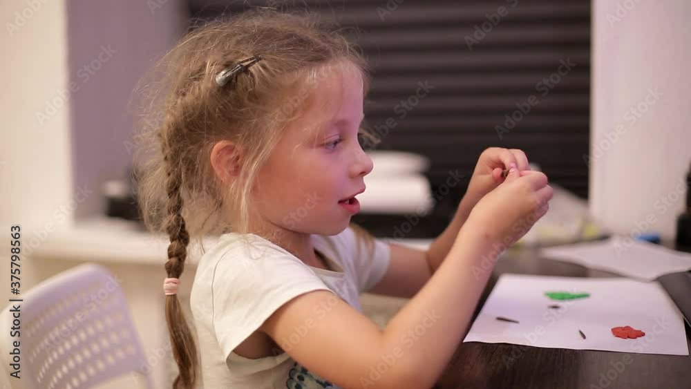 a little Caucasian girl sculpts plasticine figures, the child is engaged in Hobbies a little Caucasian girl sculpts plasticine figures, the child is engaged in Hobbies