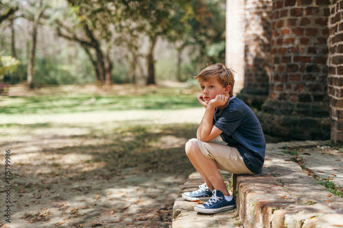 bored boy sitting alone at a park photo