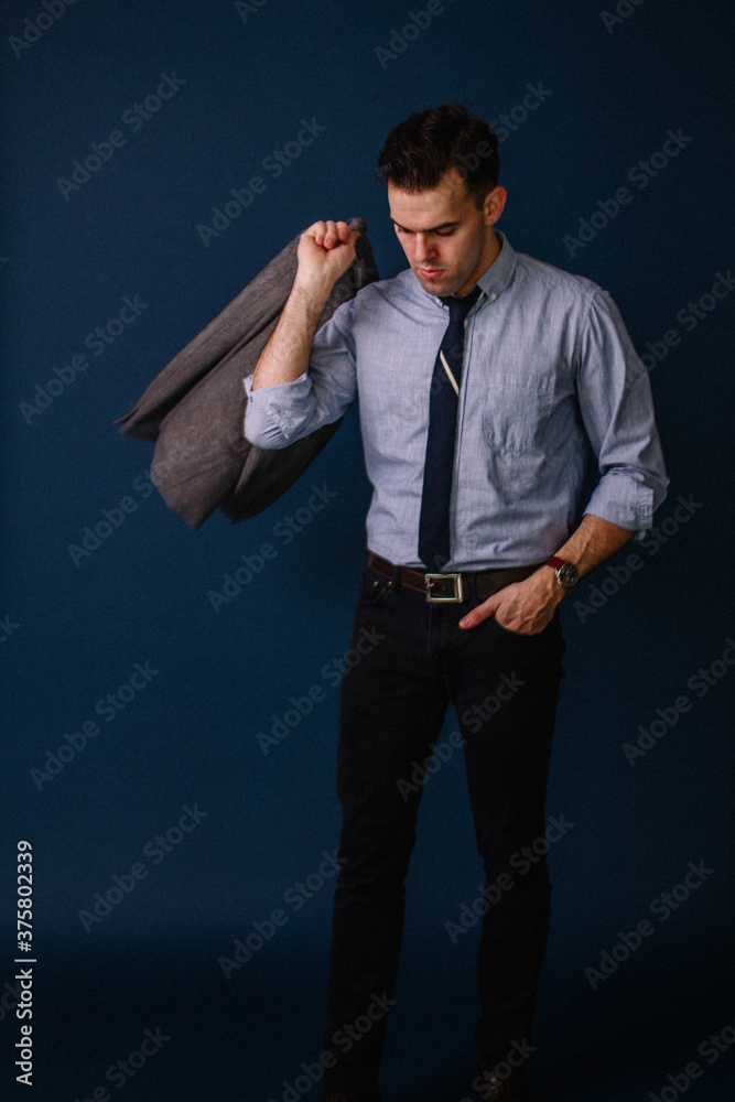 young fashionable male wearing suit in studio with blue background young fashionable male wearing suit in studio with blue background