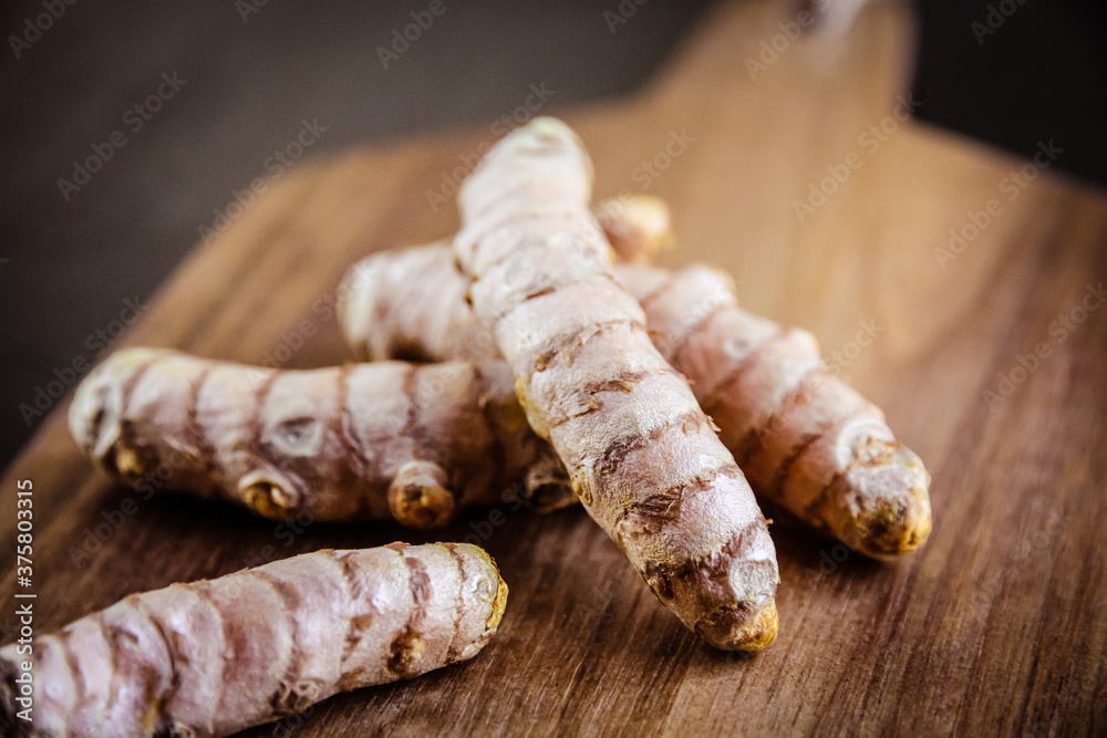 Turmeric root on a cutting board Turmeric root on a cutting board