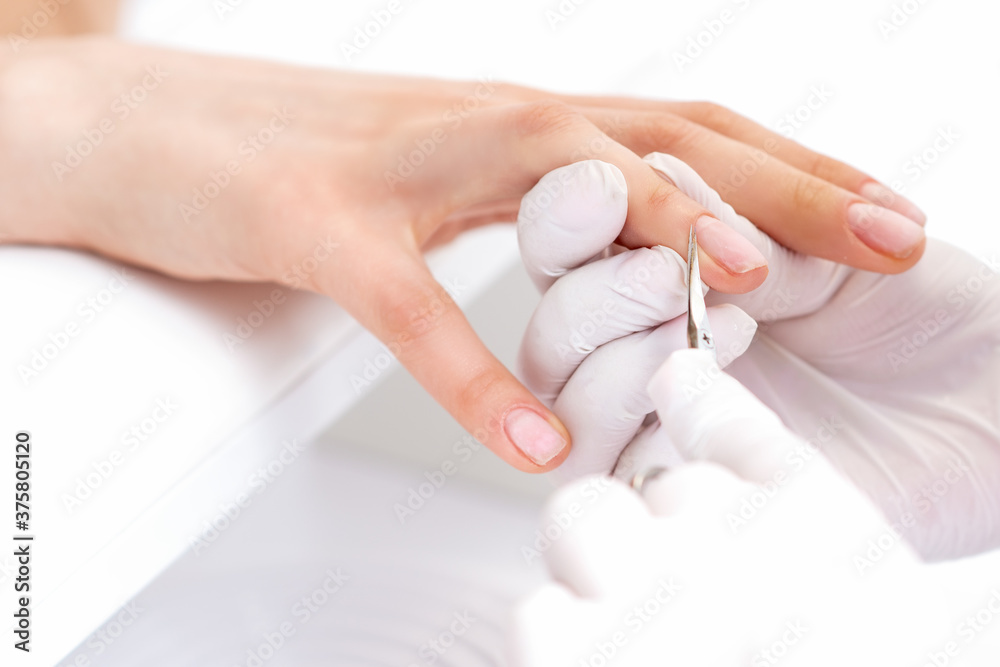 Manicure master removing nail polish with white cotton pad in beauty salon Manicure master removing nail polish with white cotton pad in beauty salon