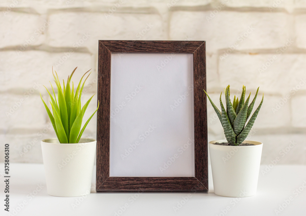An empty photo frame in a dark frame on a table or shelf with a copy of the place.