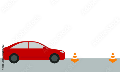 Red passenger car and two orange cones on the road