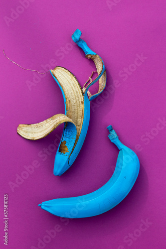 blue banana and peel bananas on purple background Stock Photo