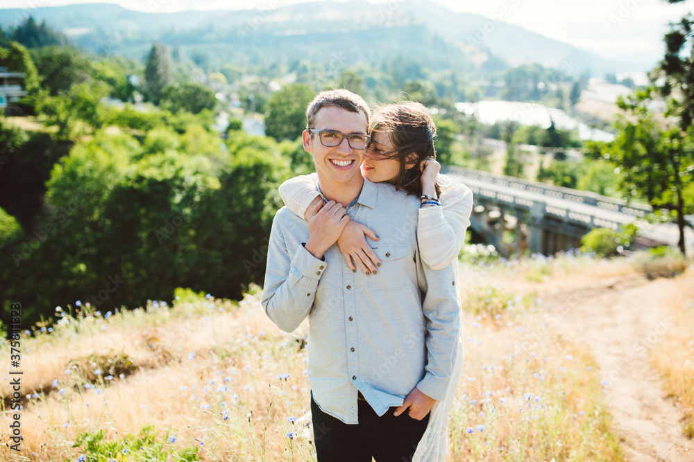 Young couple embrace on windy hilltop
