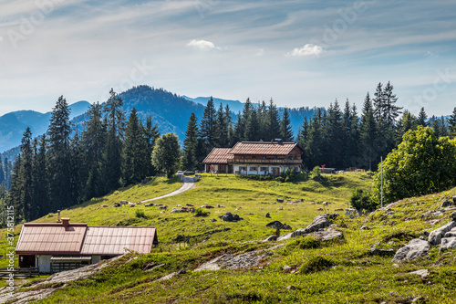 Reit im Winkl, Germany - 17th July 2020: A german photographer visiting the Winklmoosalm in Bavaria, taking pictures of a farm building on a meadow at a sunny day in summer.