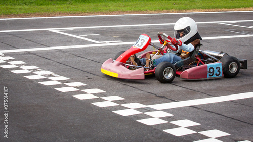 Young race kart driver about to cross the finish line