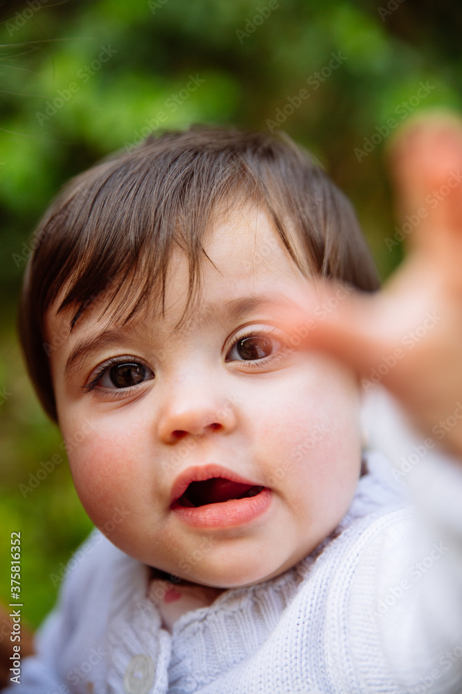 Baby girl portrait trying to reach the camera Baby girl portrait trying to reach the camera