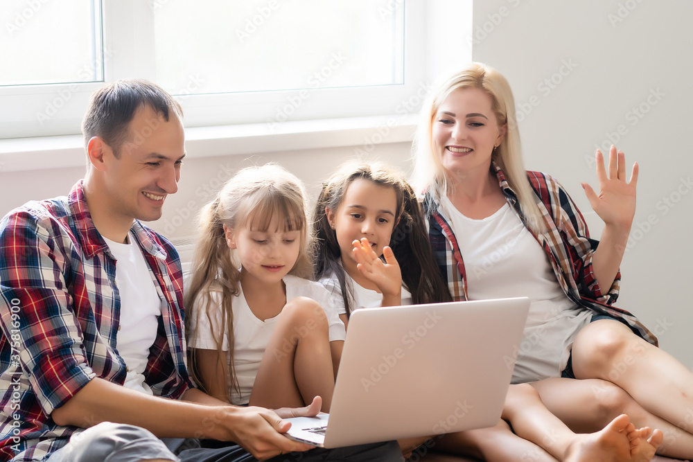 Fototapeta premium Family lying in bed using a laptop