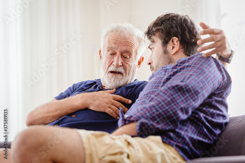 Differences of two generations male elder father with younger man son serious talking consulting together or telling history story at home.