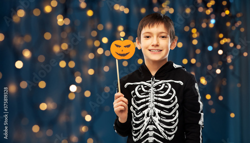 Vászonkép halloween, holiday and childhood concept - smiling boy in black costume of skele