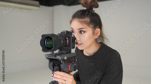 撮影現場で映像を見ている女性カメラマン