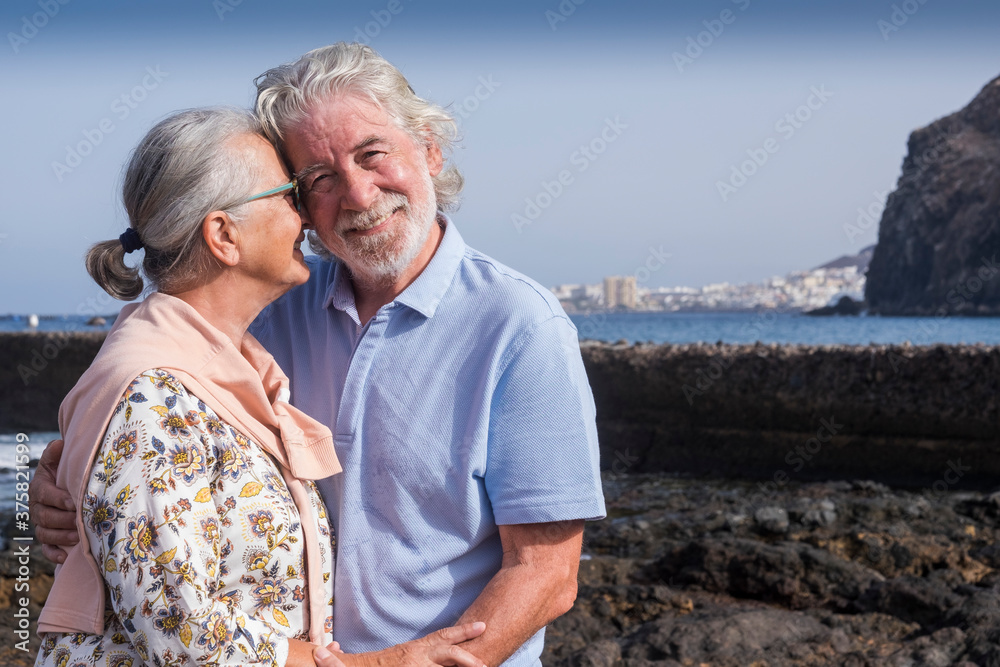 Romantic senior elderly couple embracing with love at the beach - grandparents feel happy with smile faces - relaxed lifestyle enjoying holidays Romantic senior elderly couple embracing with love at the beach - grandparents feel happy with smile faces - relaxed lifestyle enjoying holidays