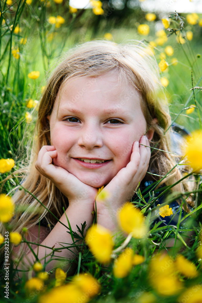 Portrait of a little girl lying in wildflowers