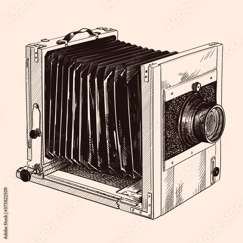 Antique formatted wooden camera with fur and lens isolated on beige background.