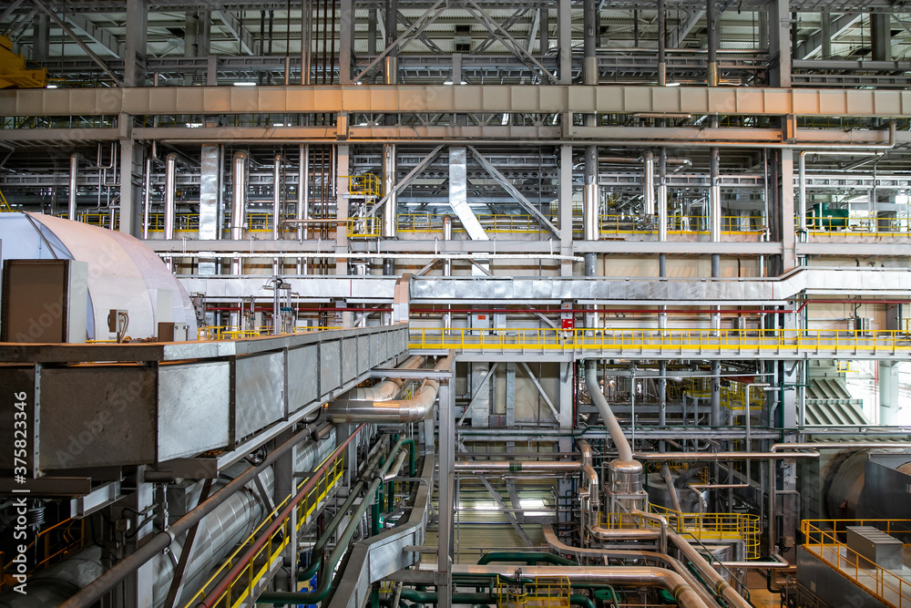 Interior of urban thermal power plant, industrial turbines, pipes Interior of urban thermal power plant, industrial turbines, pipes