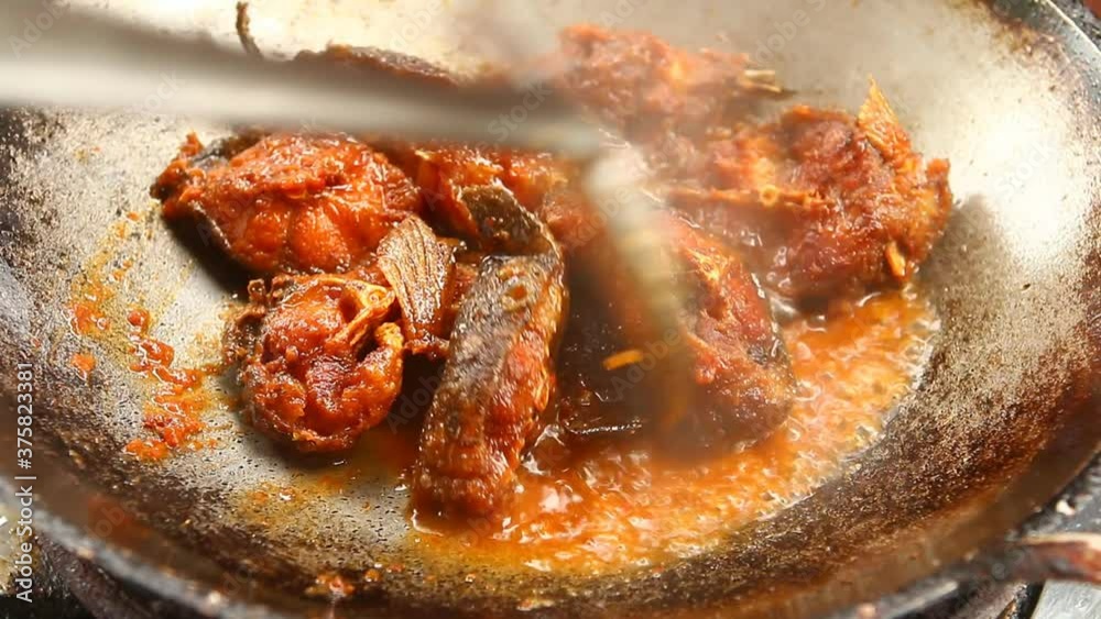 Frying chopped cat fish  with chili  in pan , in door  Chiangmai  Thailand