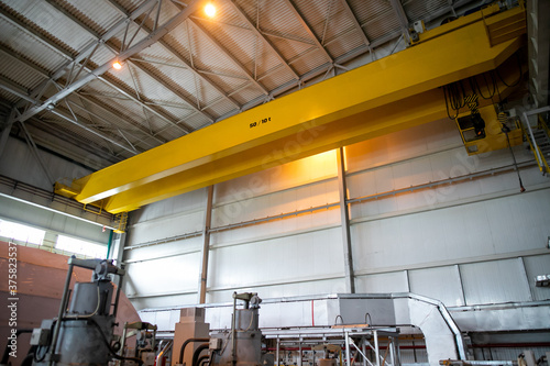 Part of an overhead crane in the background of an industrial workshop