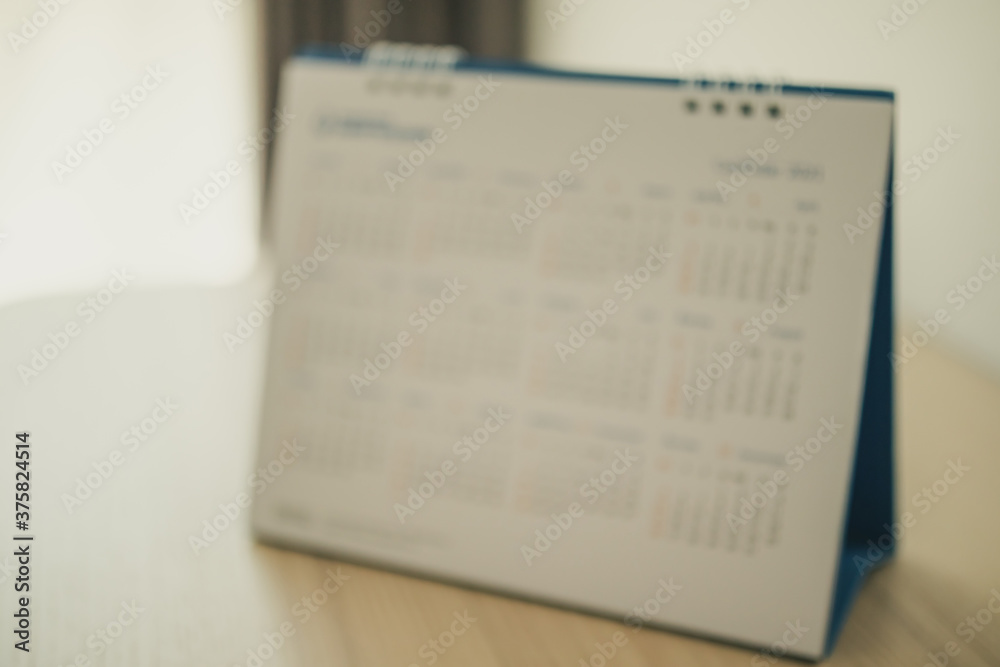 Fototapeta premium Blur calendar page close up on wood table background business planning appointment meeting concept