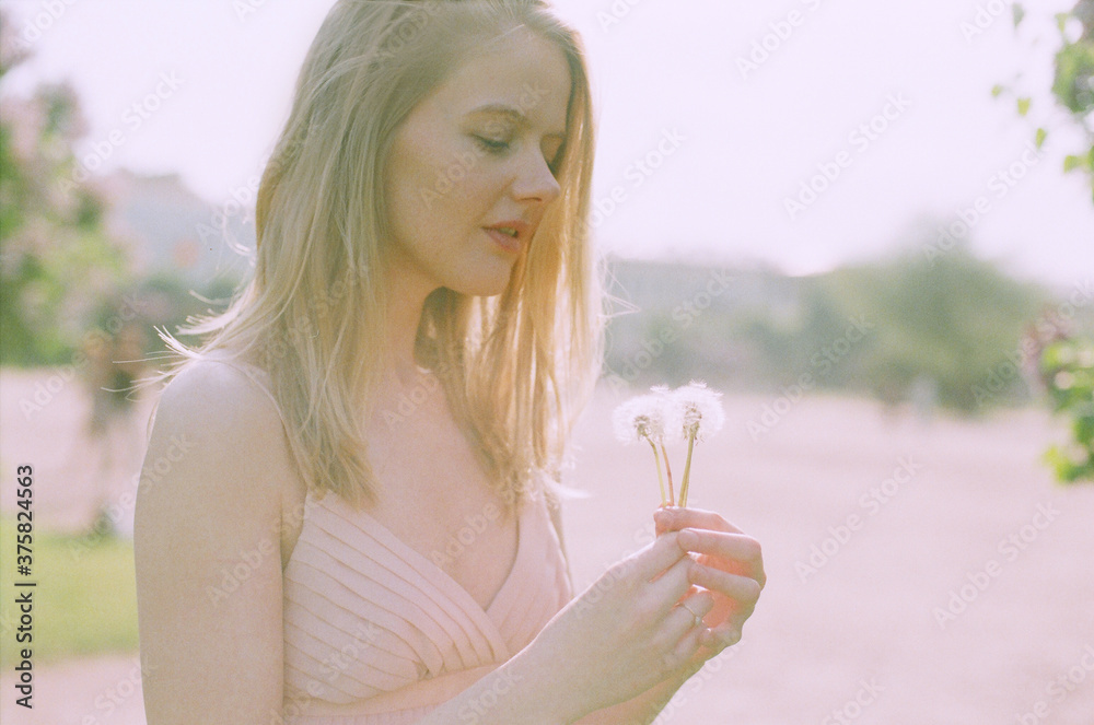 Young woman holding dandelions Young woman holding dandelions